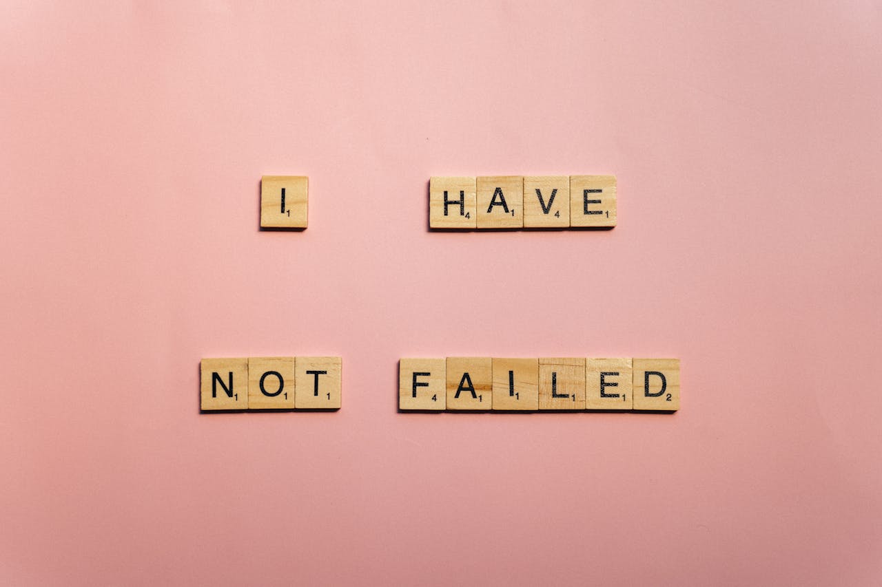 Scrabble tiles spelling 'I have not failed' on a pink background, offering an inspirational message.